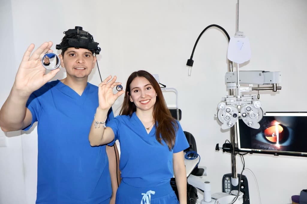 Dra. Vanessa Tirado y Dr. Manuel Trujillo en consultorio diagnóstico con equipo oftalmológico y lentes de fondo de ojo